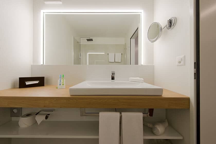 Bathroom vanity with backlit LED mirror and magnifying mirror