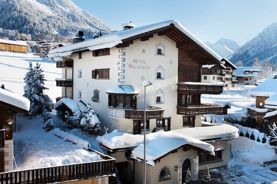 Alpine chalet exterior with private balconies and mountain views