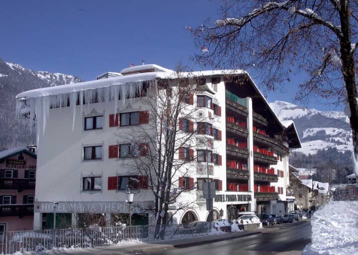 Hotel exterior with private balconies and street-level parking near ski slopes
