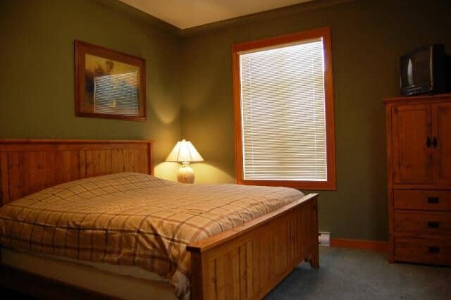 Bedroom with king bed and armoire featuring a TV