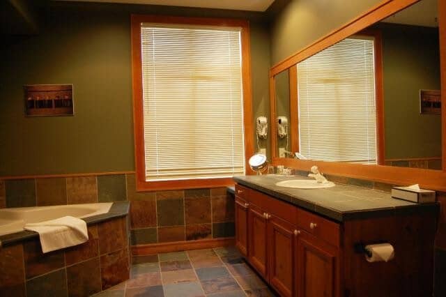Bathroom with corner soaking tub and slate tile flooring