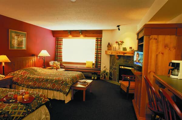 Studio suite with two beds, gas fireplace, and built-in window seat