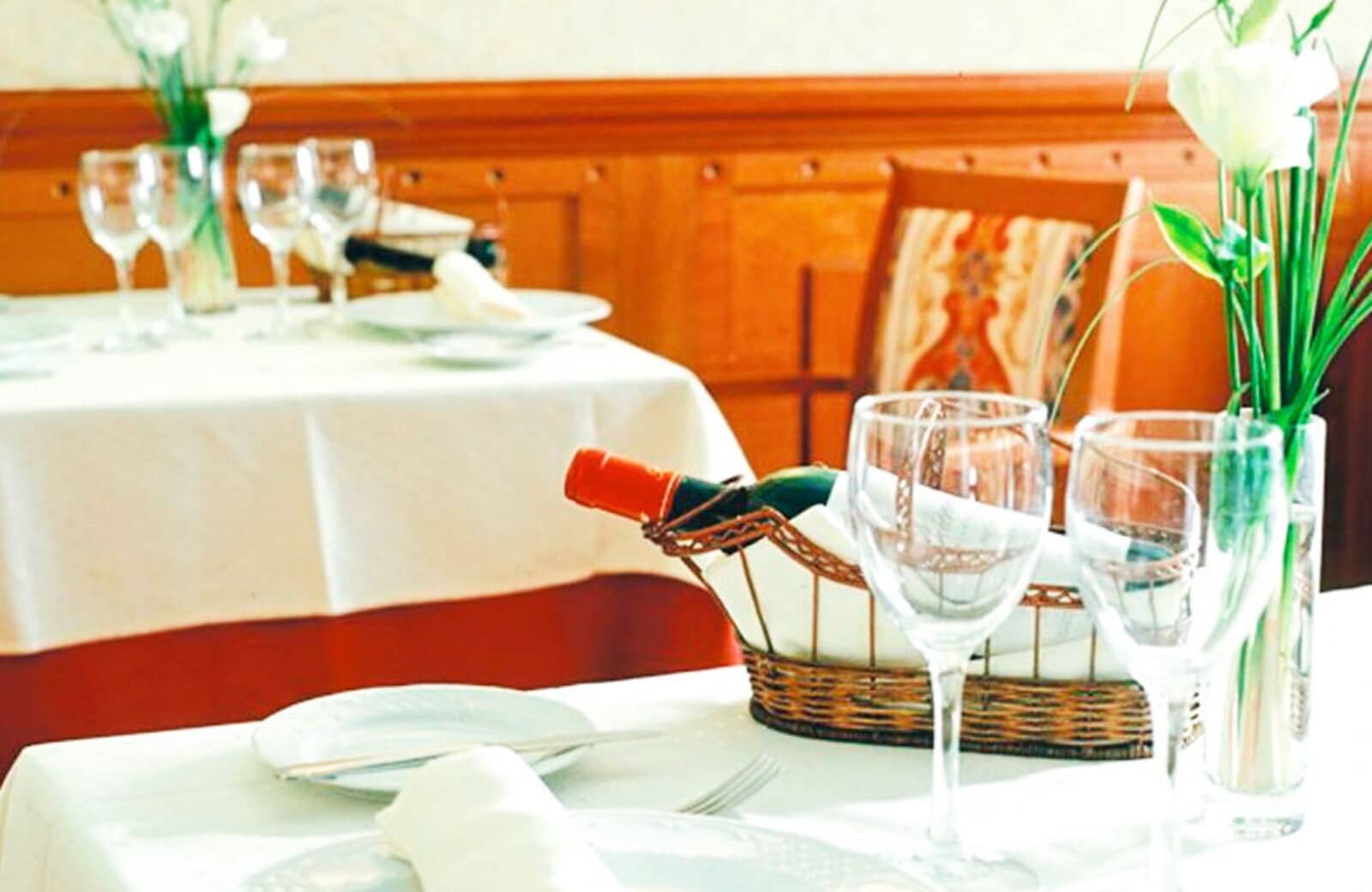 Dining area with traditional wood paneling and white linen service