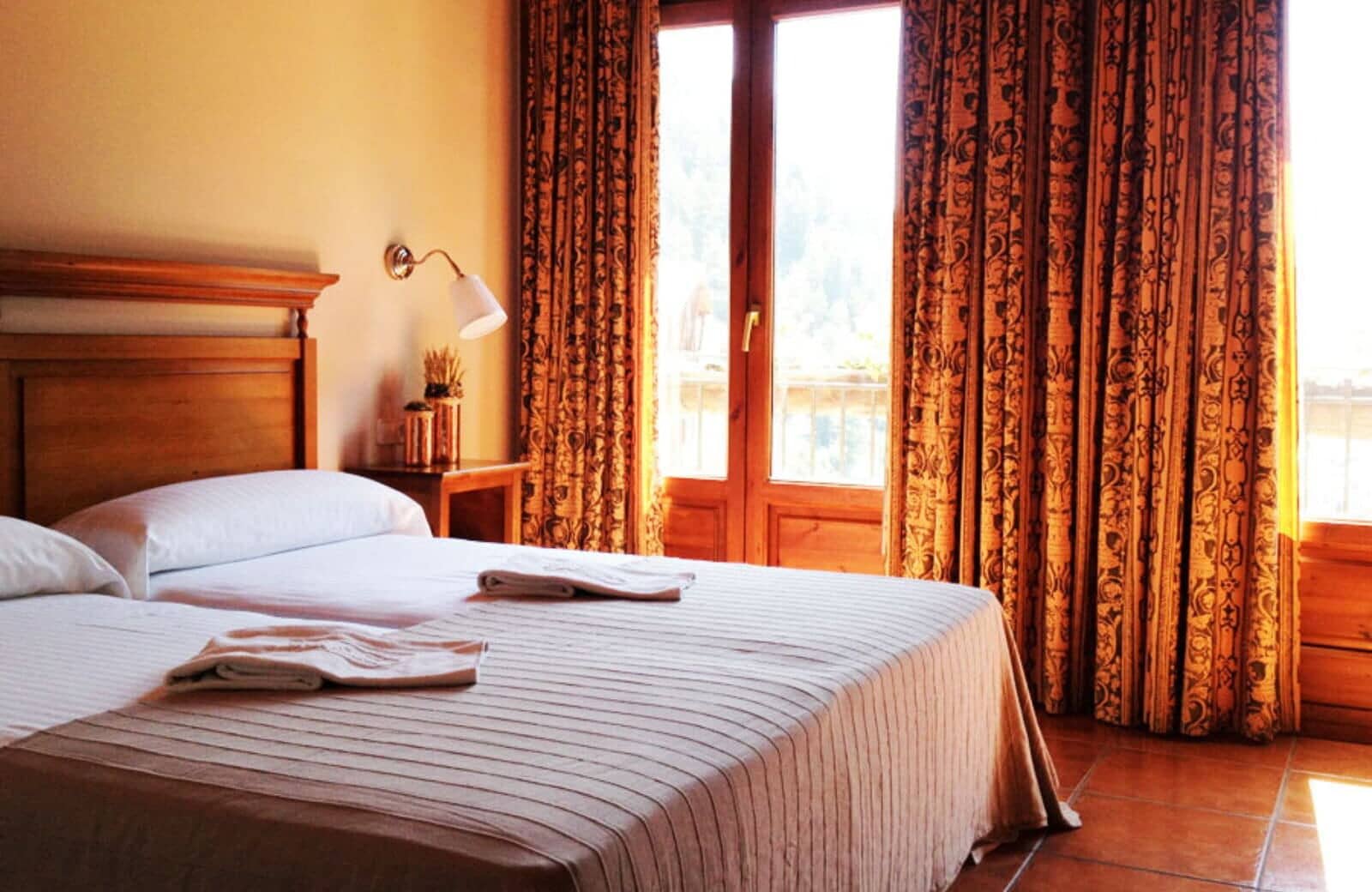 Bedroom with twin beds and balcony access; mountain views
