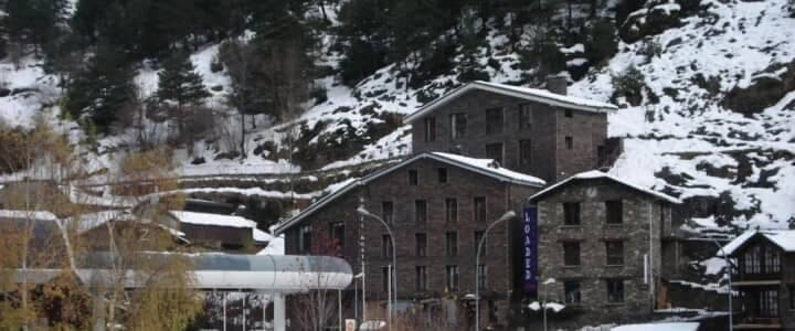 Stone buildings on snowy mountainside; located next to ski lift