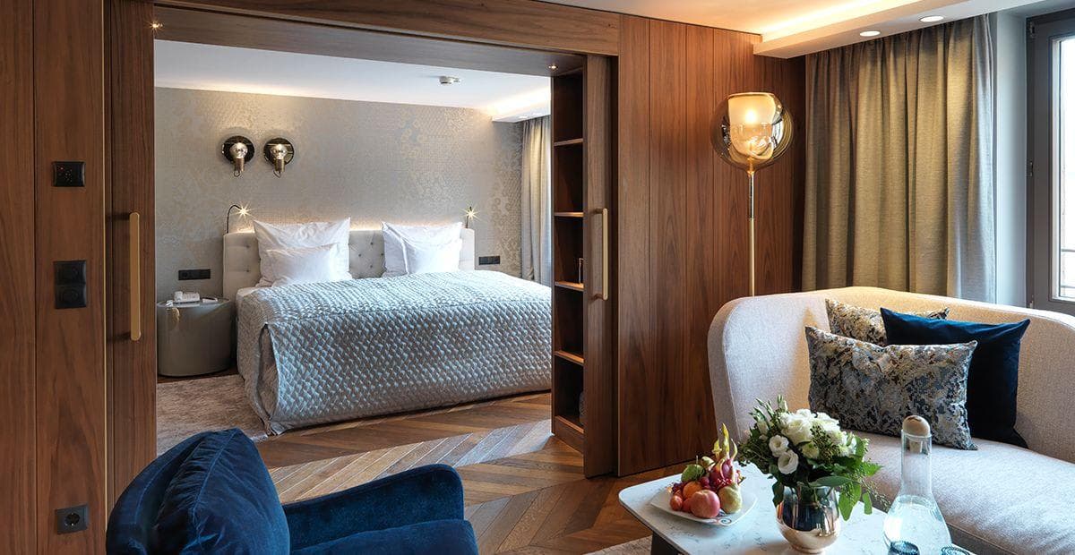 Living area and bedroom with king bed and walnut sliding doors