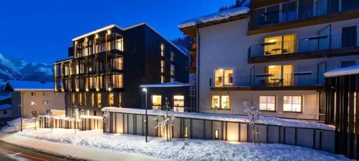 Ski resort exterior at dusk with private balconies and mountain views