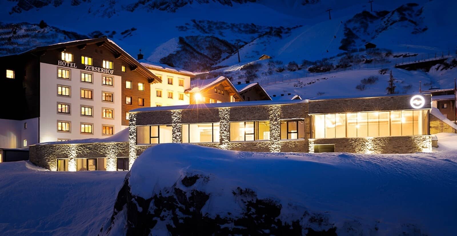 Ski-in/ski-out hotel exterior with direct access to illuminated mountain slopes