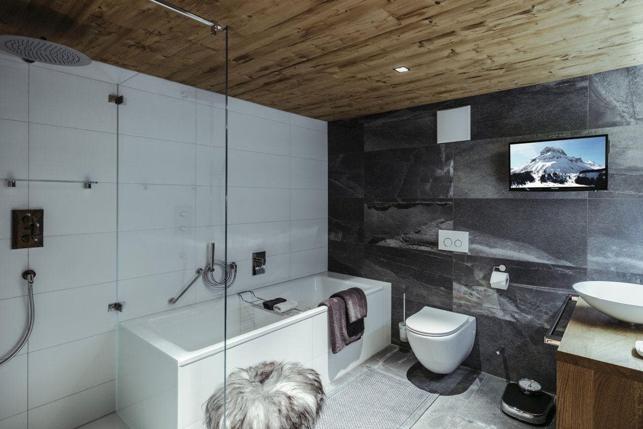 Bathroom with soaking tub, rainfall showerhead, and wall-mounted TV