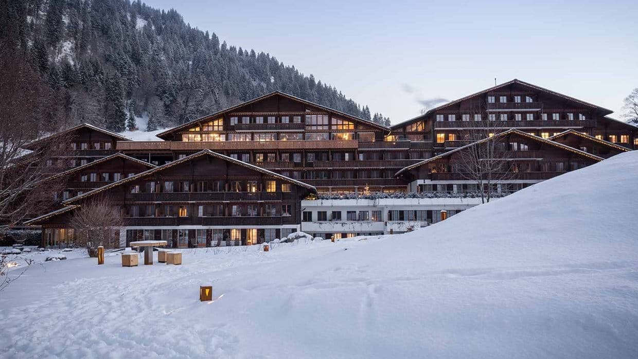 Ski-in/ski-out chalet exterior with private terrace and mountain forest backdrop