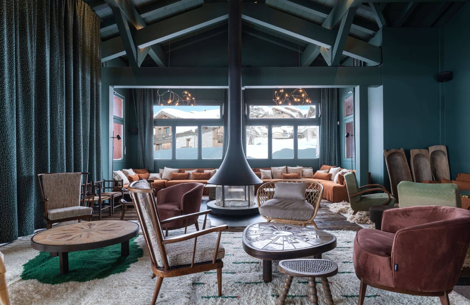 Lounge with central wood-burning fireplace and mountain views