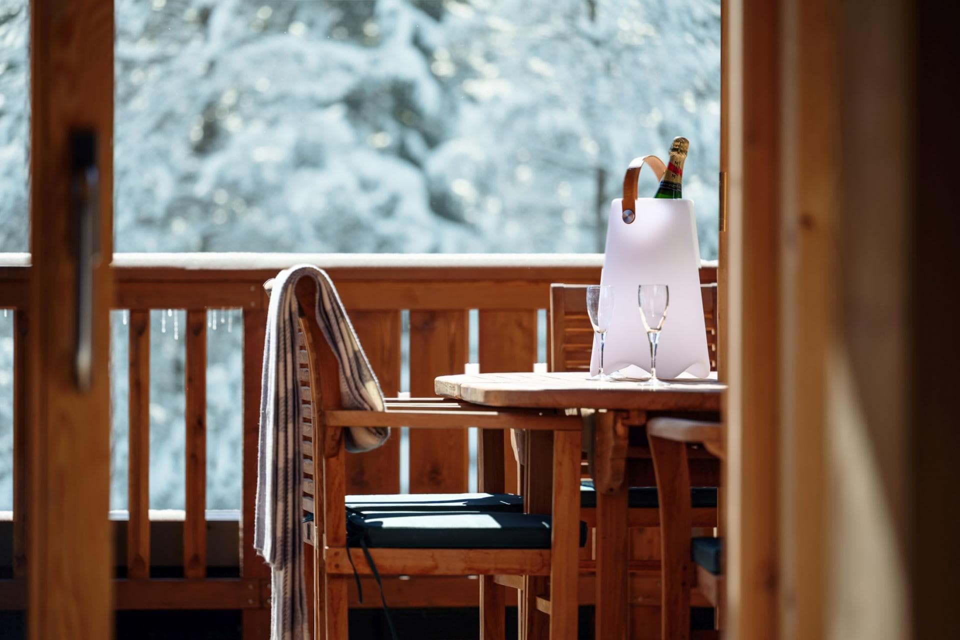 Private balcony with wooden dining set and forest views