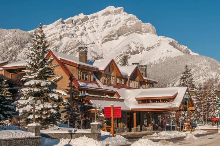 Timber-frame lodge exterior with covered entrance and Cascade Mountain backdrop