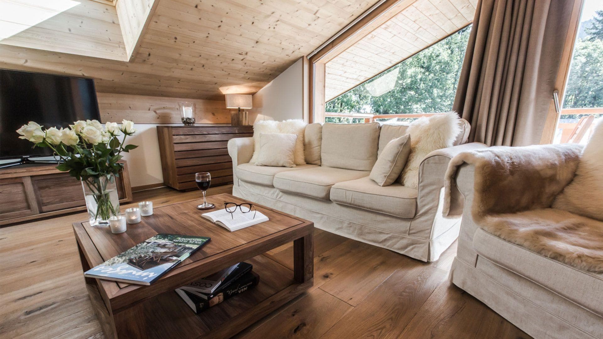 Top-floor living area with vaulted wood ceilings and balcony access