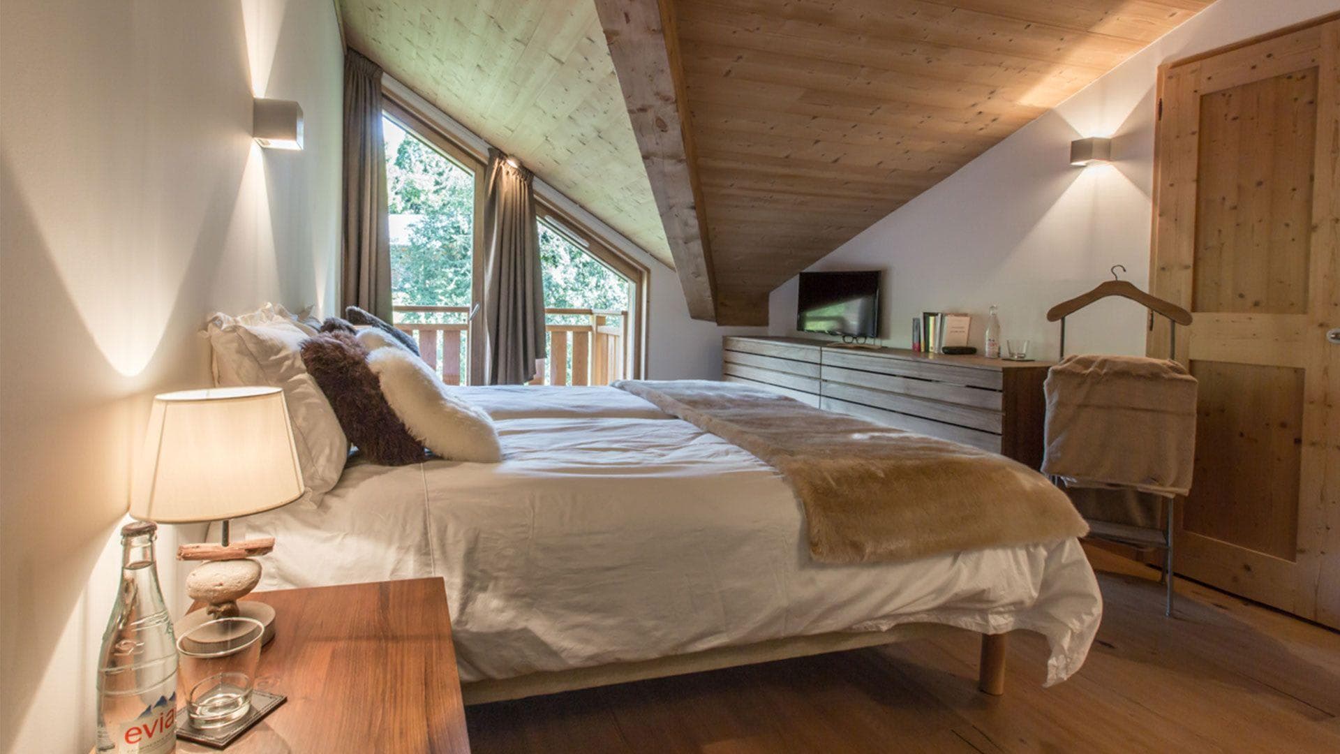 Attic bedroom with king bed, vaulted wood ceiling, and private balcony