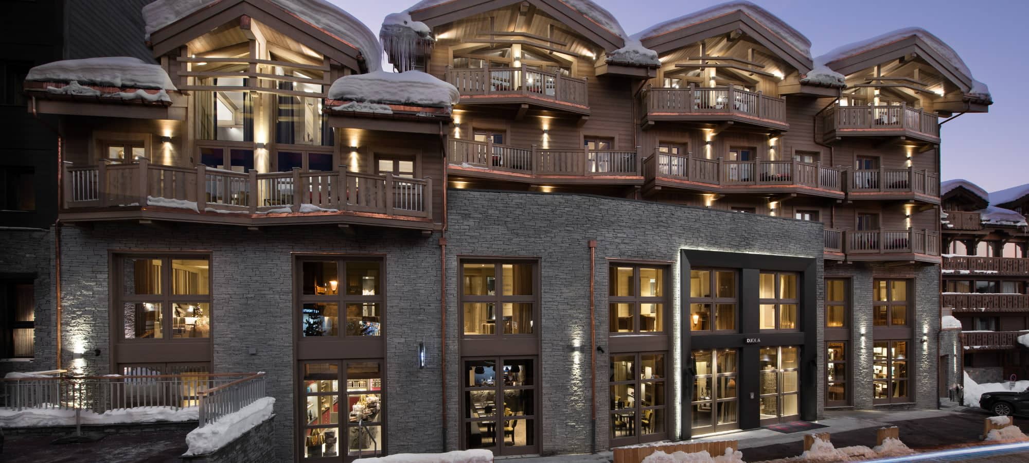 Ski-in ski-out chalet exterior with private balconies and stone facade