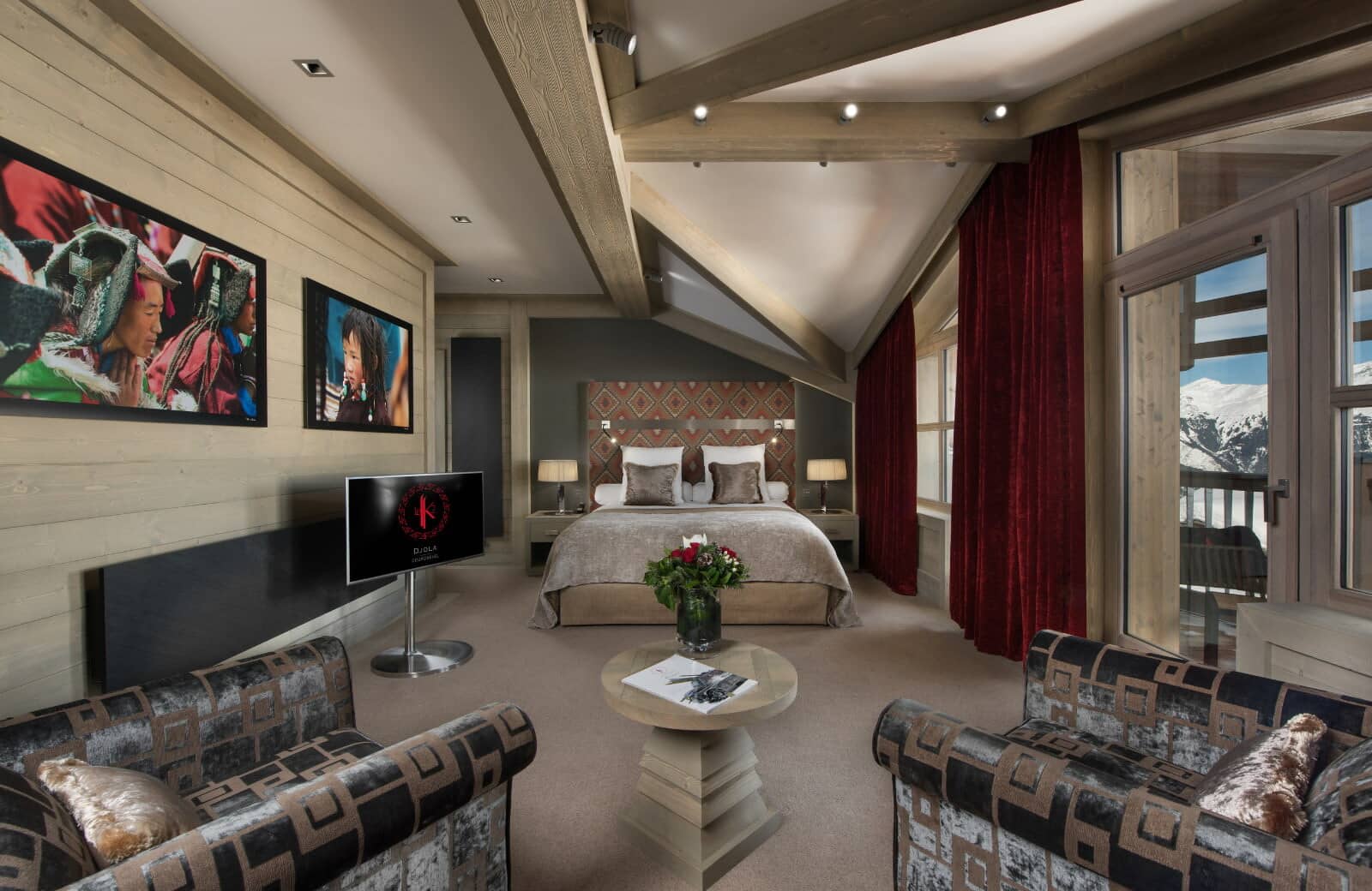 Primary suite with king bed, lounge area, and mountain view balcony