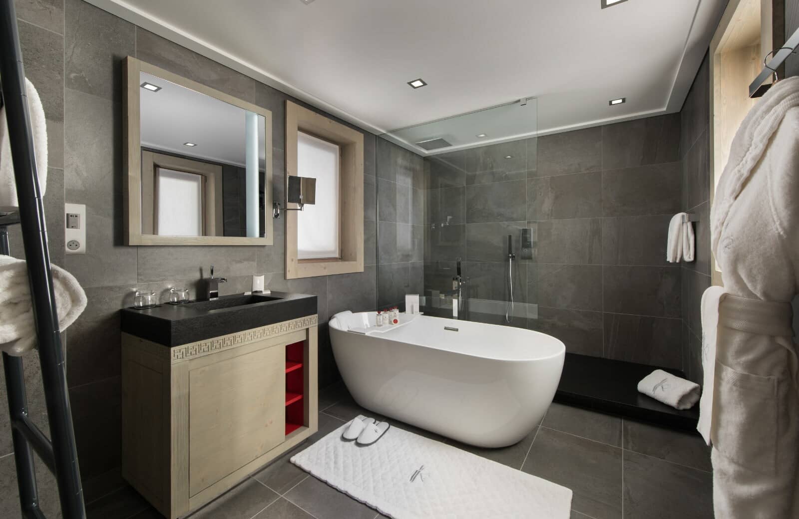 Bathroom with soaking tub, rainfall shower, and heated towel rack