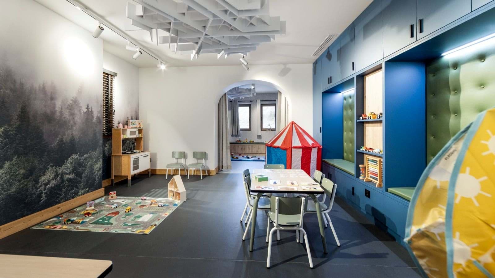 Children's playroom with craft table, play kitchen, and built-in toy storage