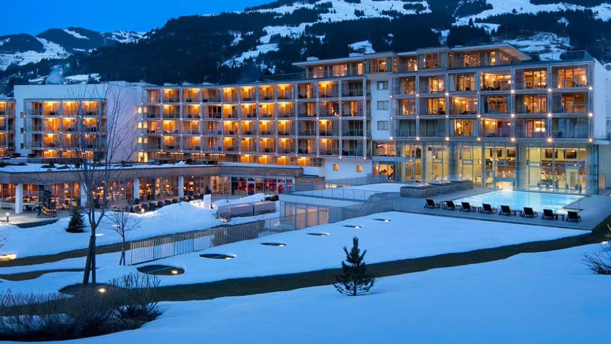 Ski-in/ski-out resort exterior with heated outdoor pool and mountain backdrop