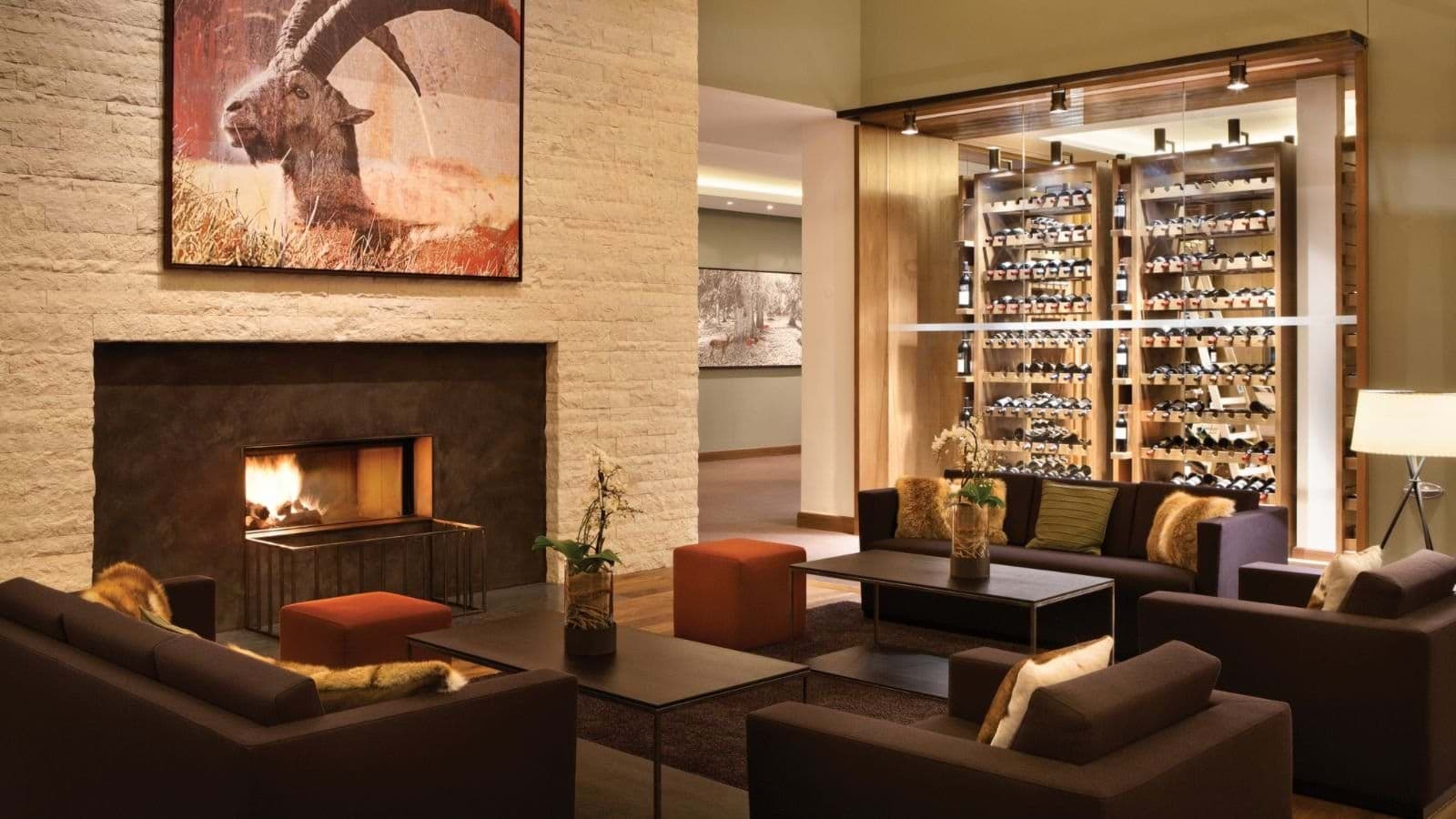 Lounge area with wood-burning fireplace and floor-to-ceiling wine display