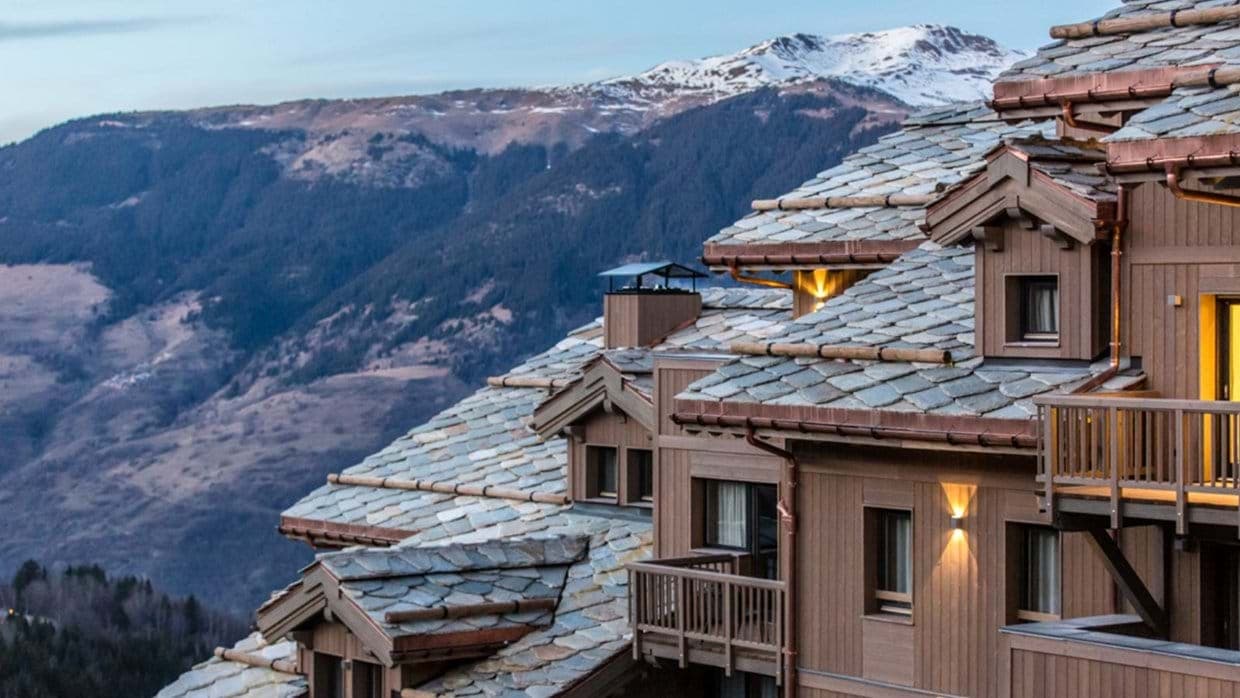 Chalet exterior with private balconies and snow-capped mountain views