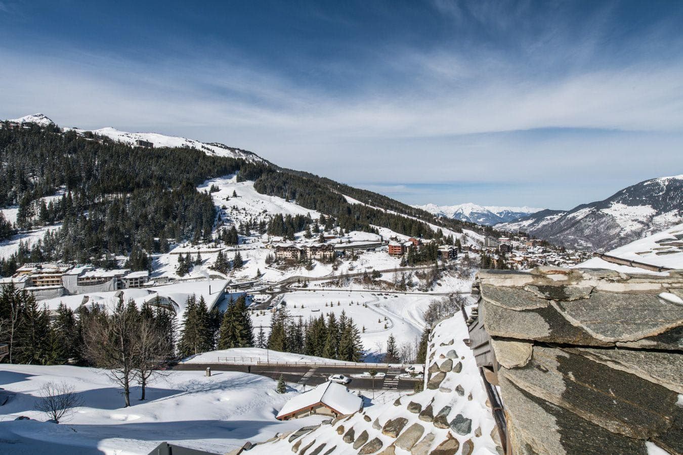 Ski resort views from private balcony overlooking snow-covered peaks and village