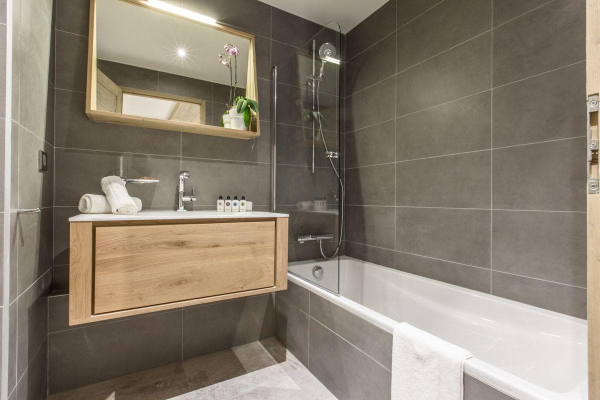 Bathroom with floating vanity and soaking tub with glass splash guard