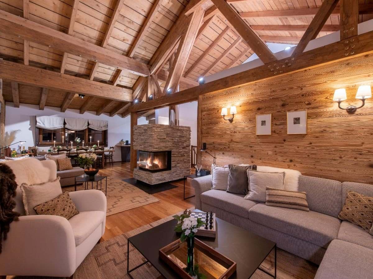 Open-plan living area with vaulted timber ceilings and stone fireplace