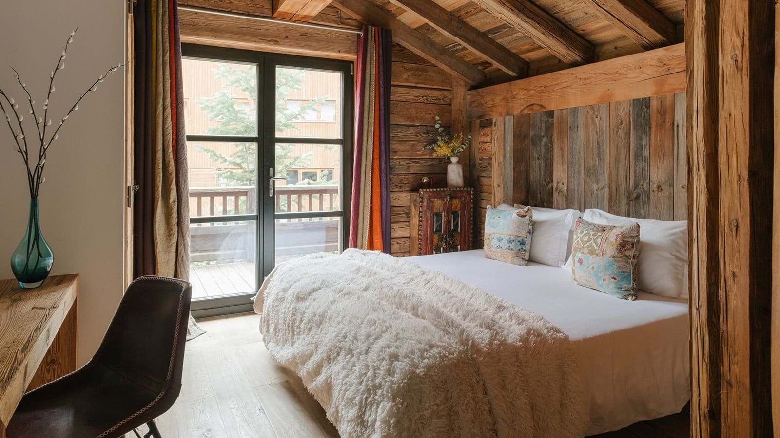 Guest bedroom with balcony access and reclaimed wood walls