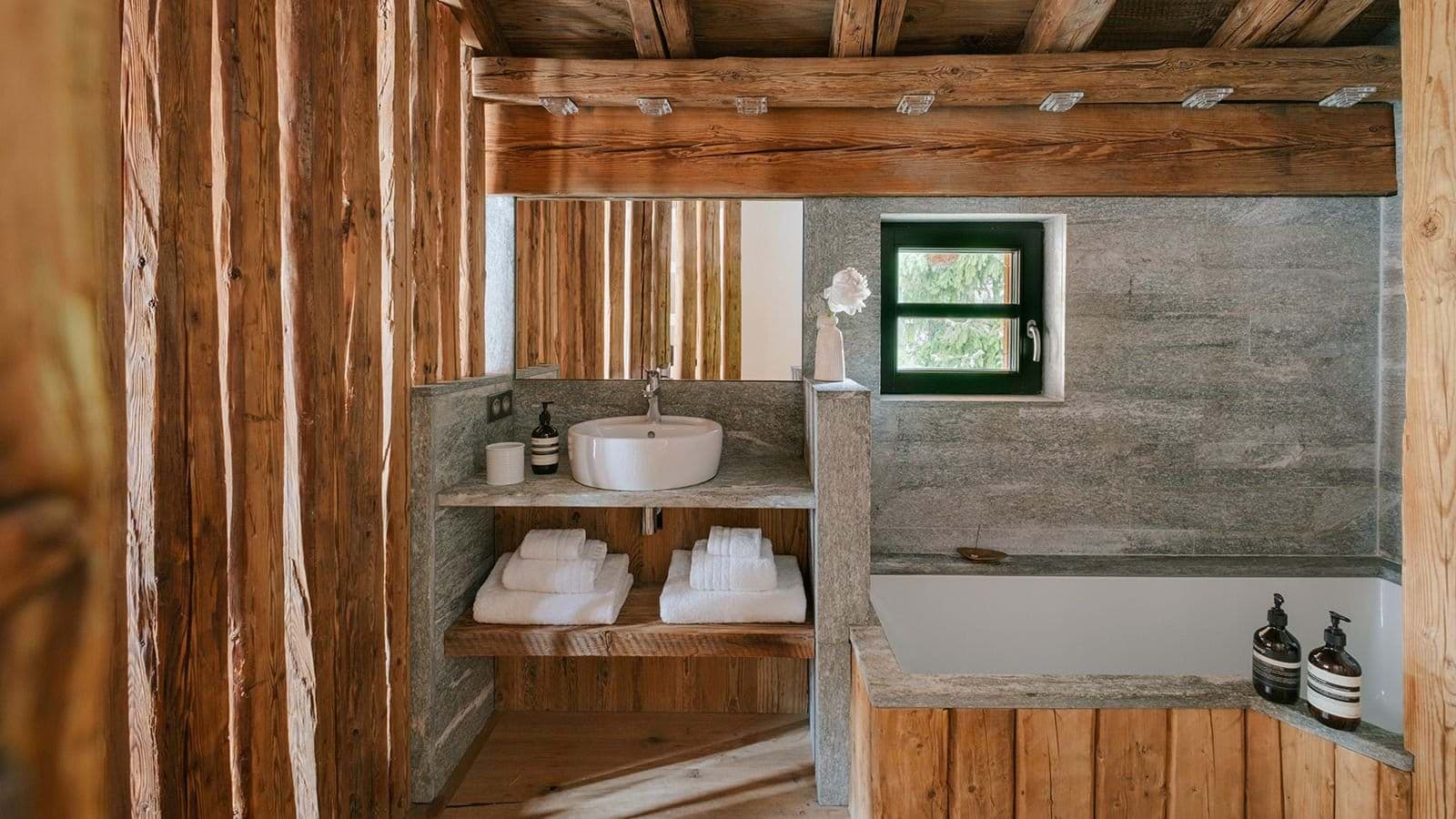 Bathroom with vessel sink and wood-paneled soaking tub
