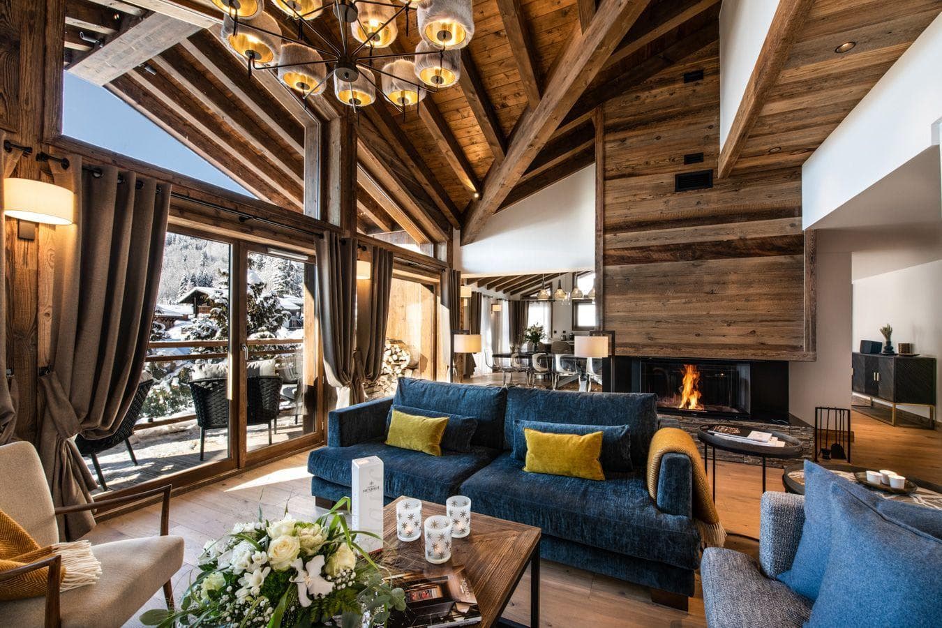 Living area with wood-burning fireplace and floor-to-ceiling mountain views