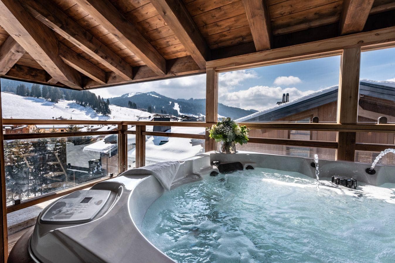 Covered balcony hot tub with views of the ski slopes