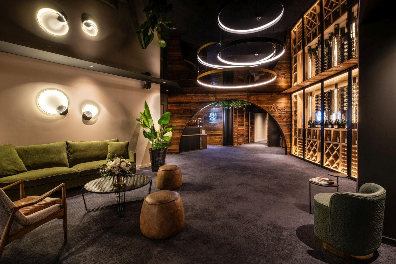 Lounge area with velvet seating and floor-to-ceiling temperature-controlled wine display