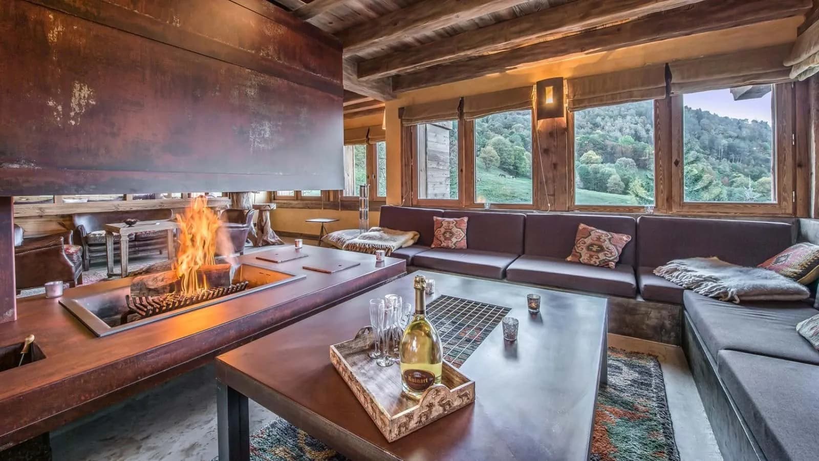 Lounge area with central open-hearth fireplace and valley views
