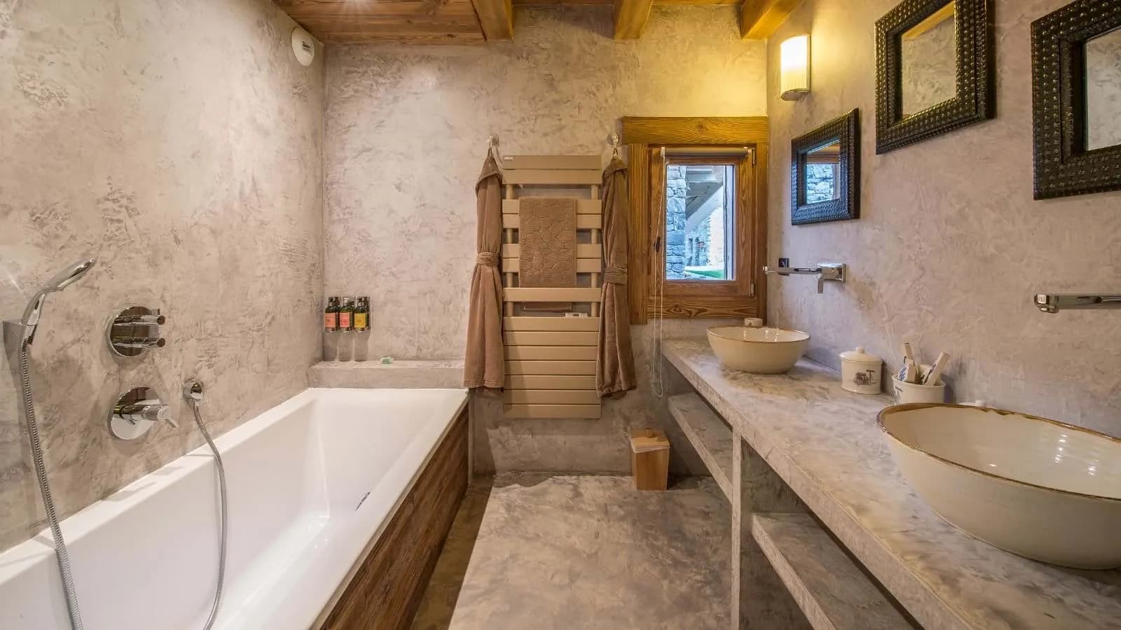 Bathroom with dual vessel sinks, soaking tub, and heated towel rack