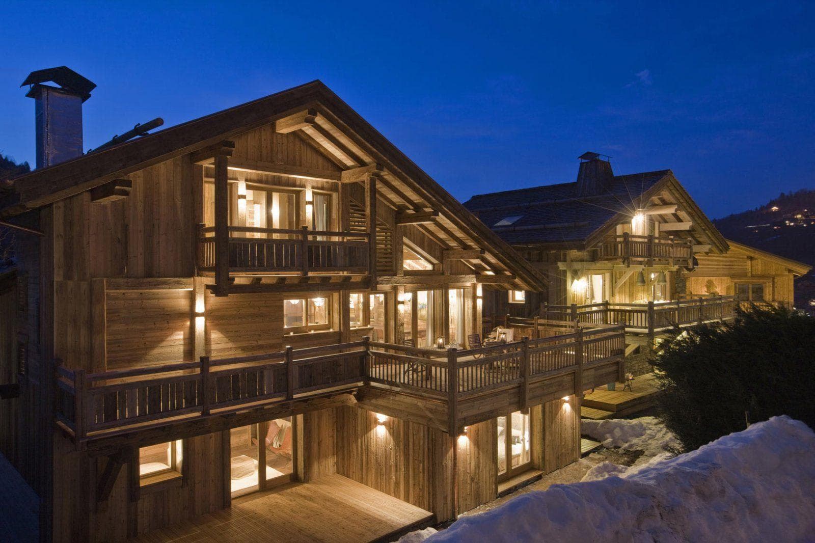 Chalet exterior with multi-level timber decks and valley views at dusk