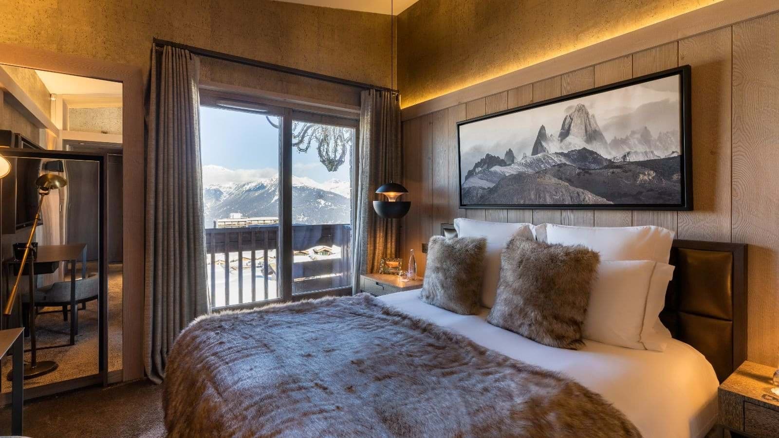 Primary bedroom with king bed, mountain views, and private balcony access