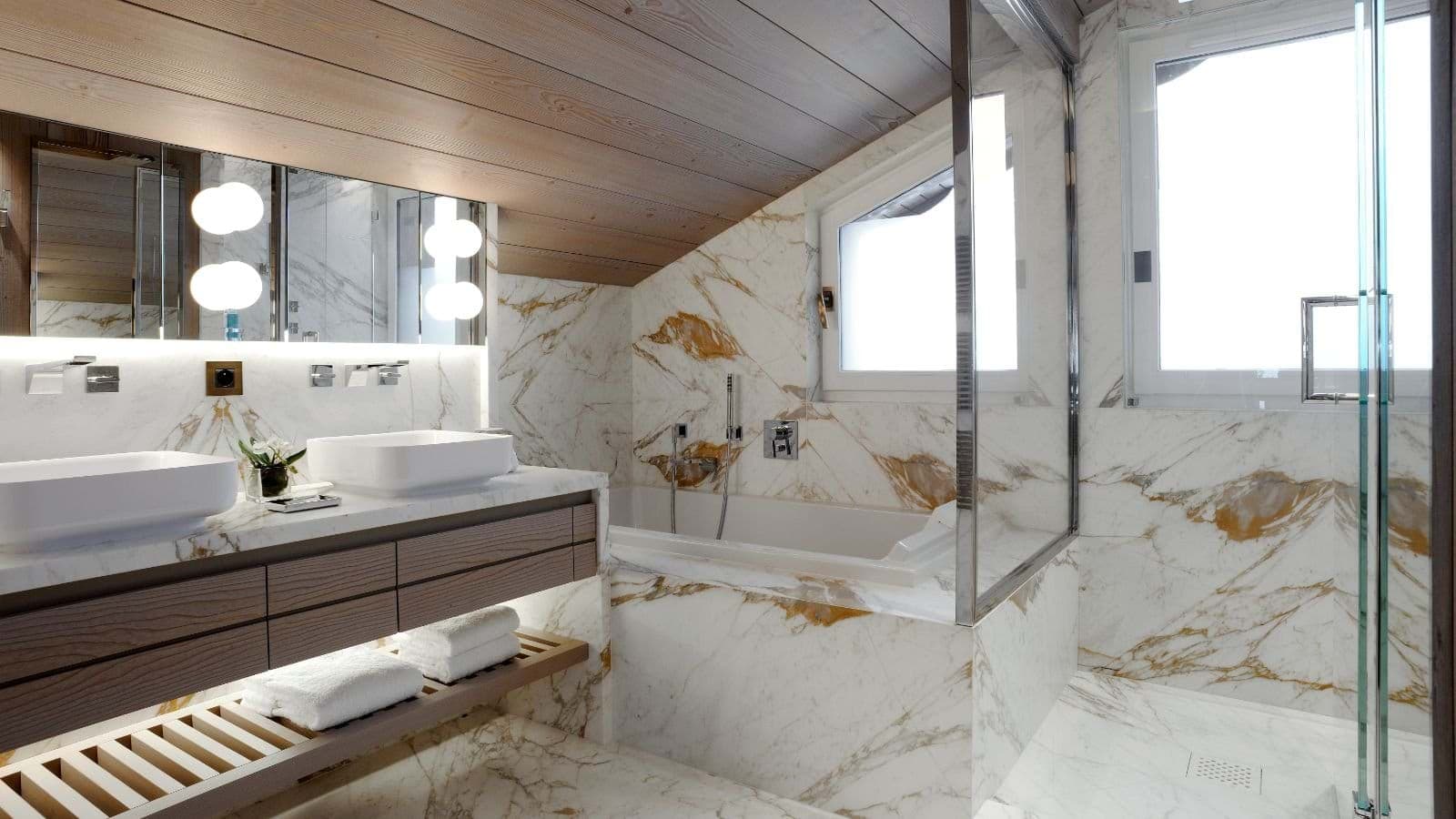 Bathroom with dual vessel sinks, soaking tub, and marble walk-in shower