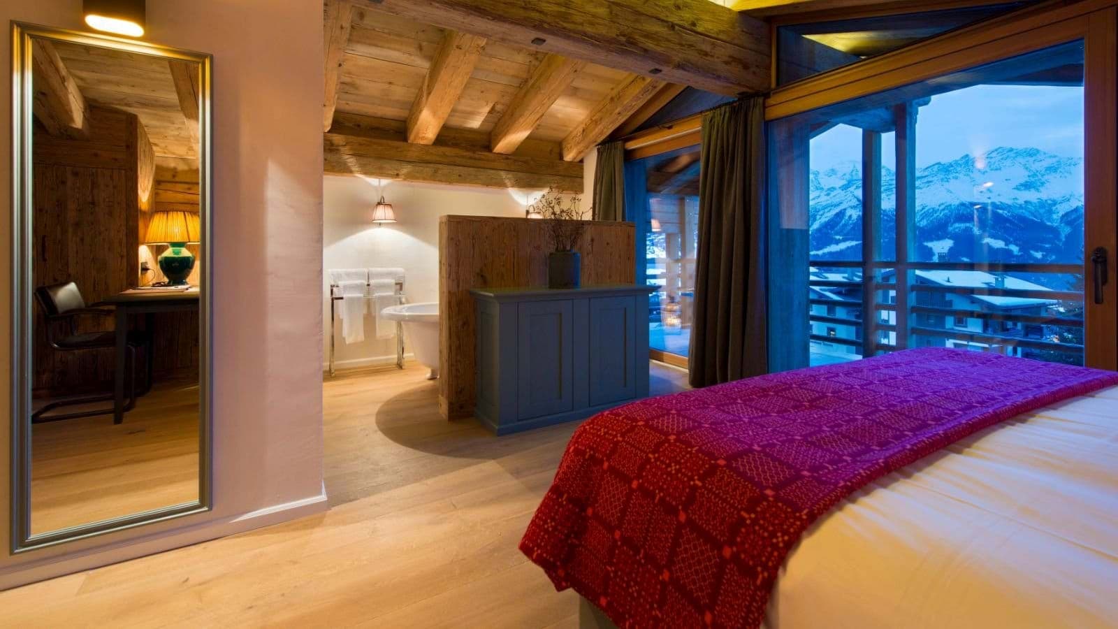 Primary bedroom with en suite soaking tub and mountain peak views