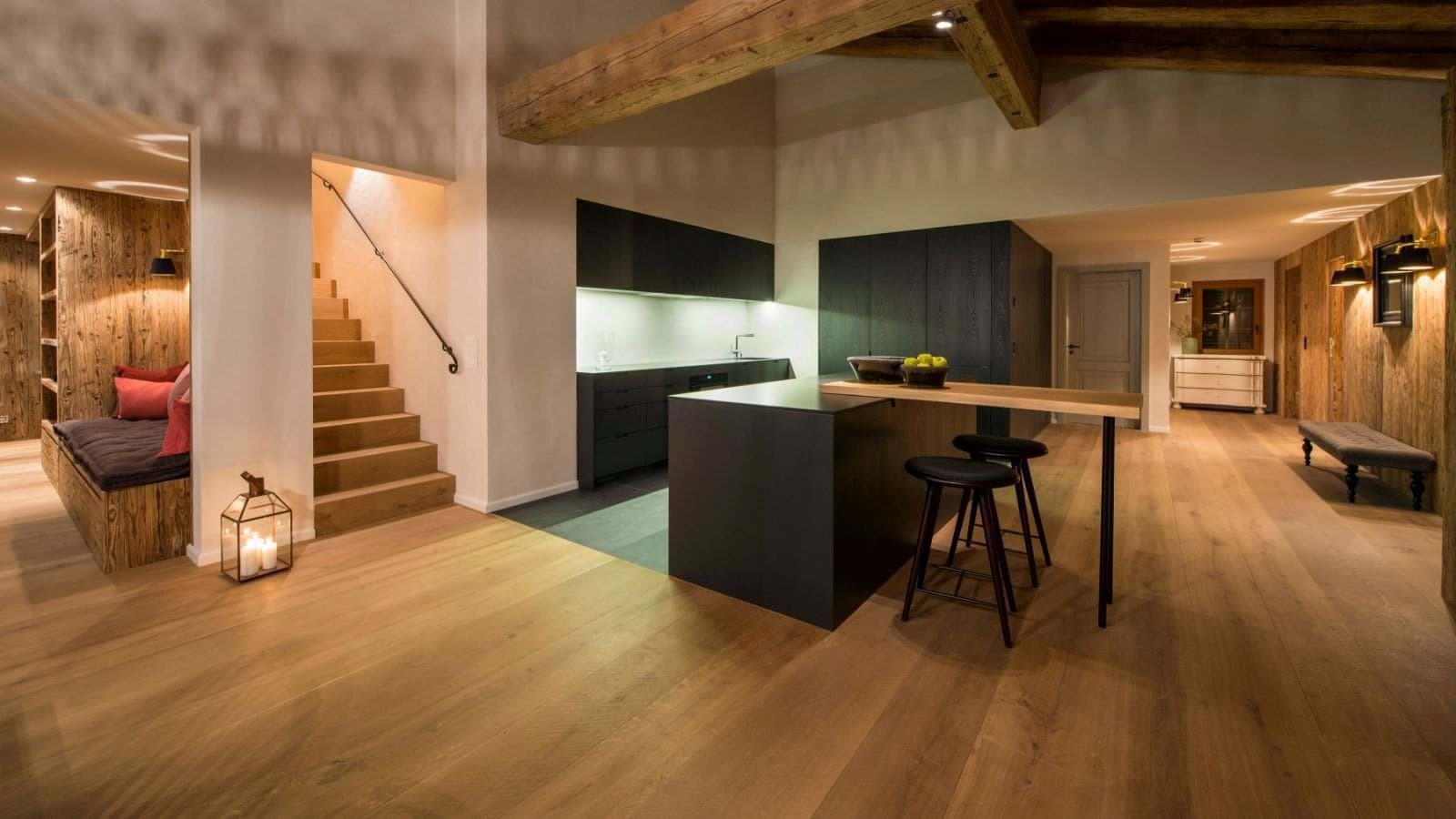 Open-plan kitchen with breakfast bar seating and adjacent reading nook