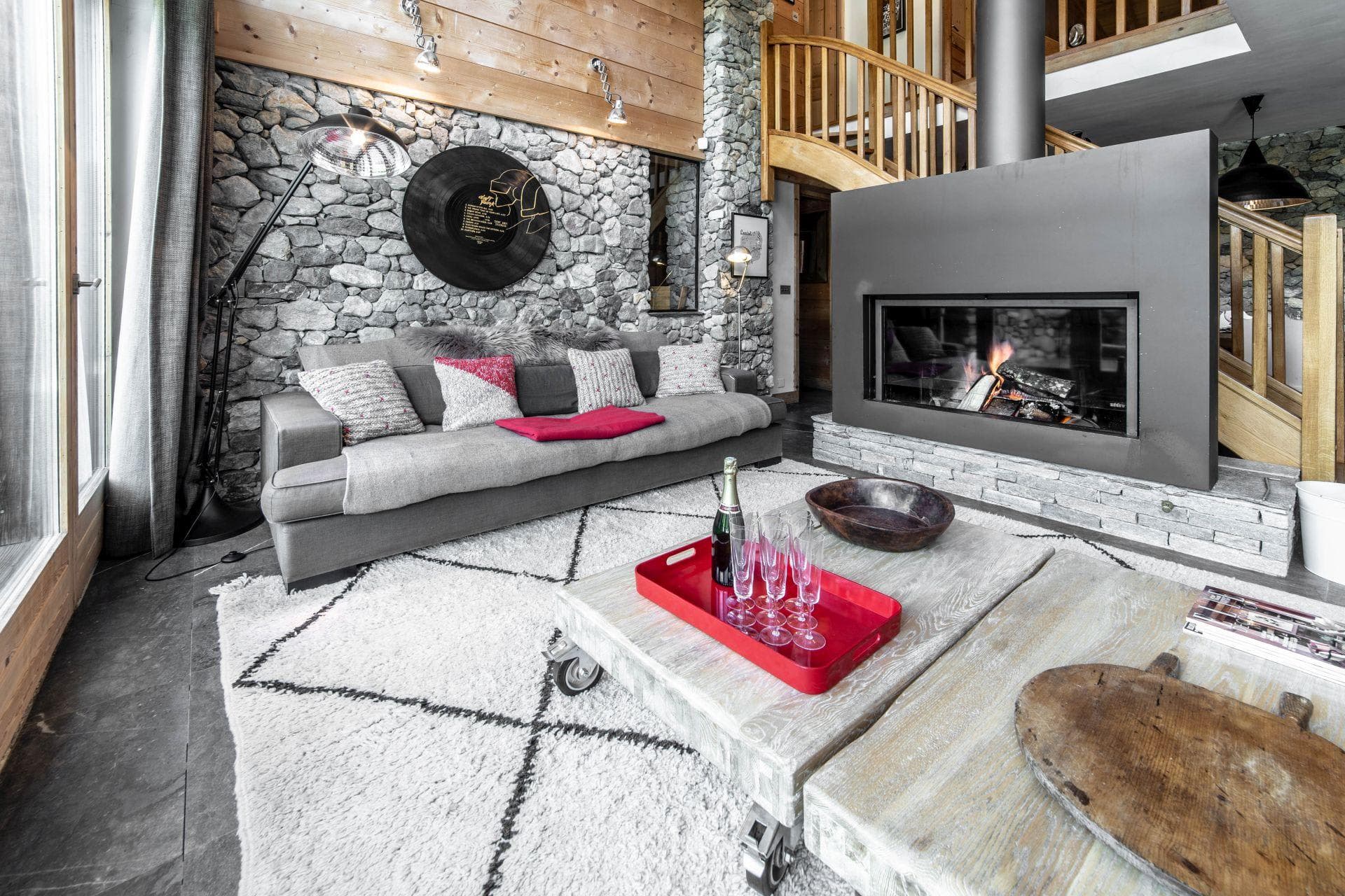 Living area with wood-burning fireplace and stone feature wall