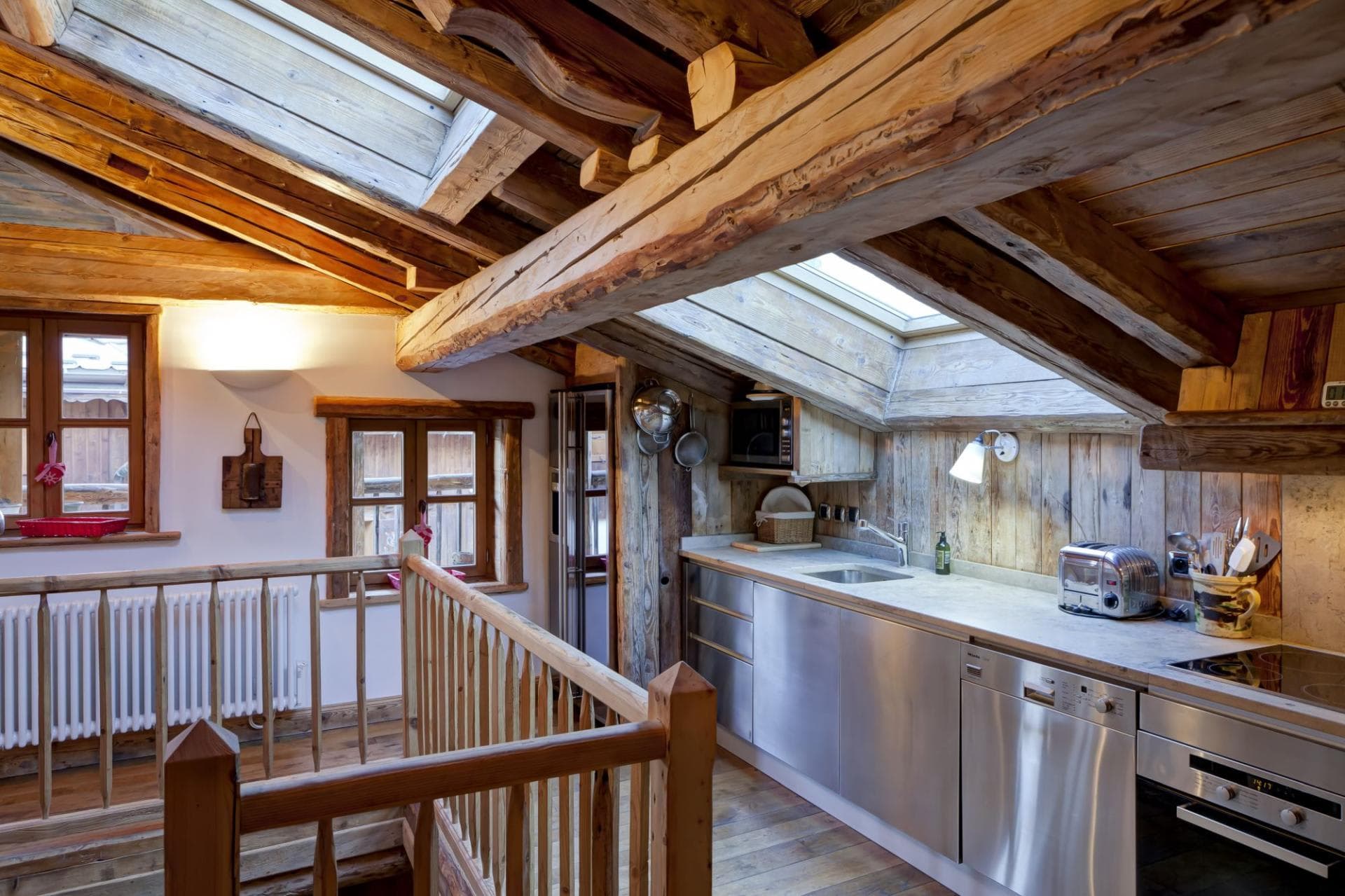 Attic kitchenette with skylights, dishwasher, and exposed timber beams