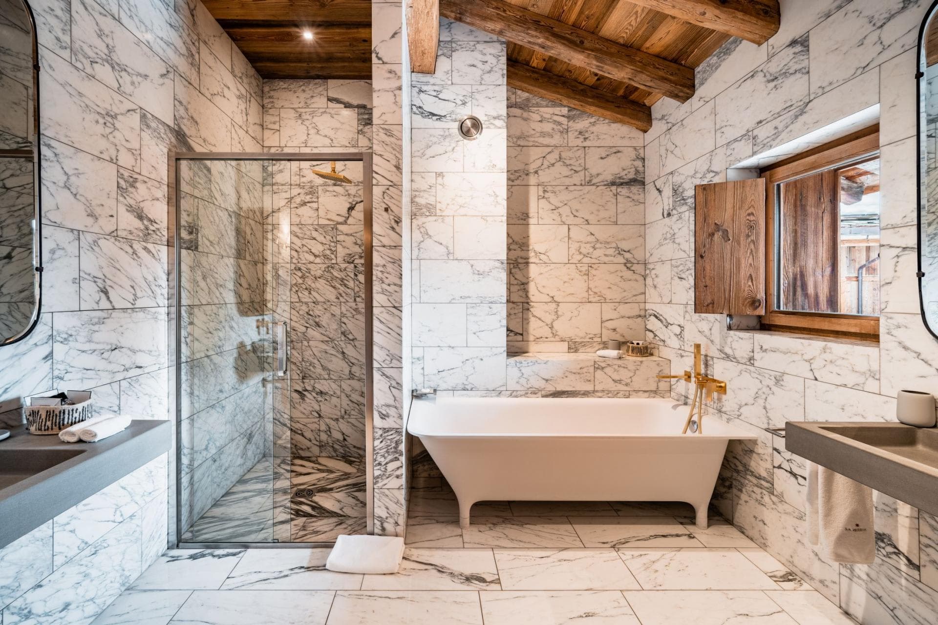 Bathroom with marble tile, walk-in shower, and freestanding soaking tub