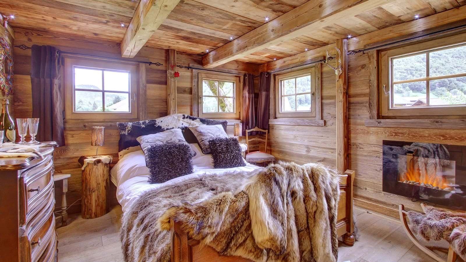 Guest bedroom with queen bed, electric fireplace, and reclaimed wood walls
