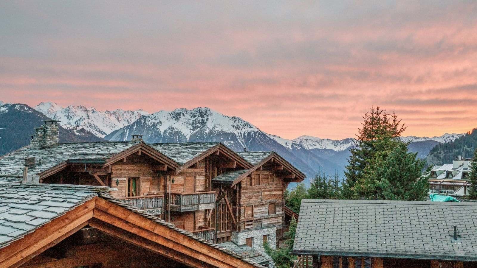 Chalet balcony view of snow-capped Alps at sunset