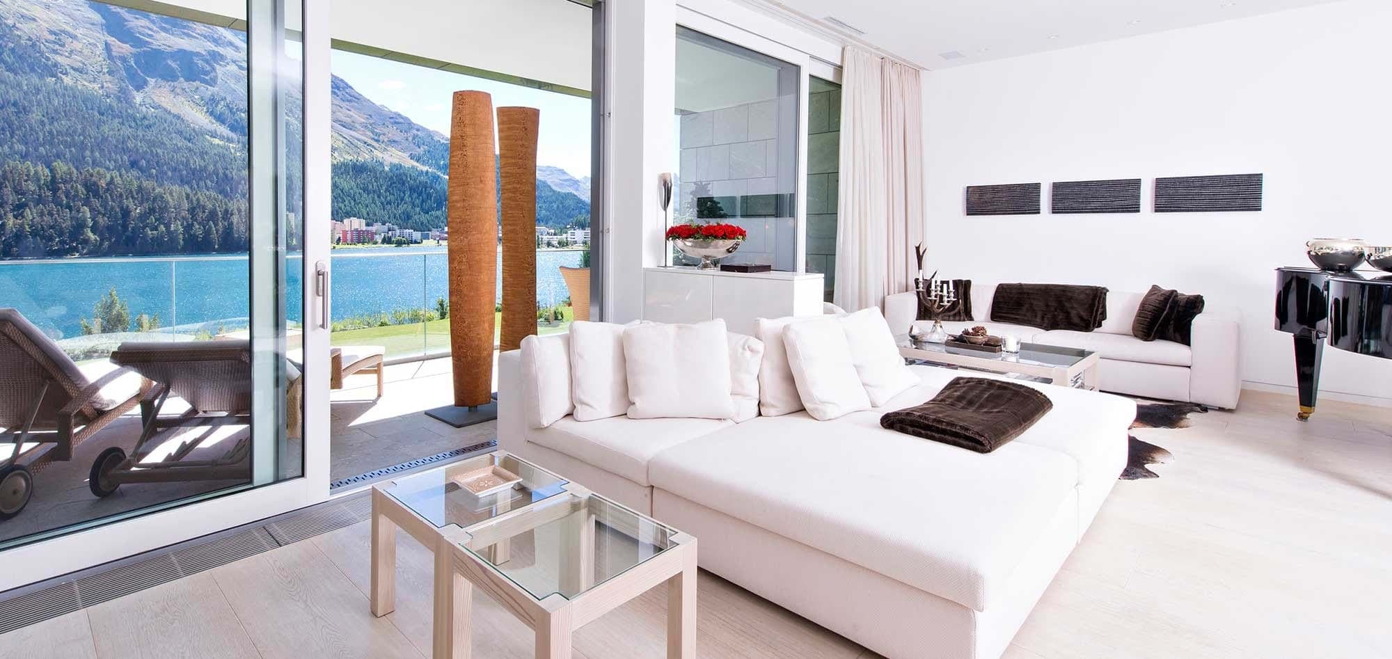 Living area with baby grand piano and lakefront balcony