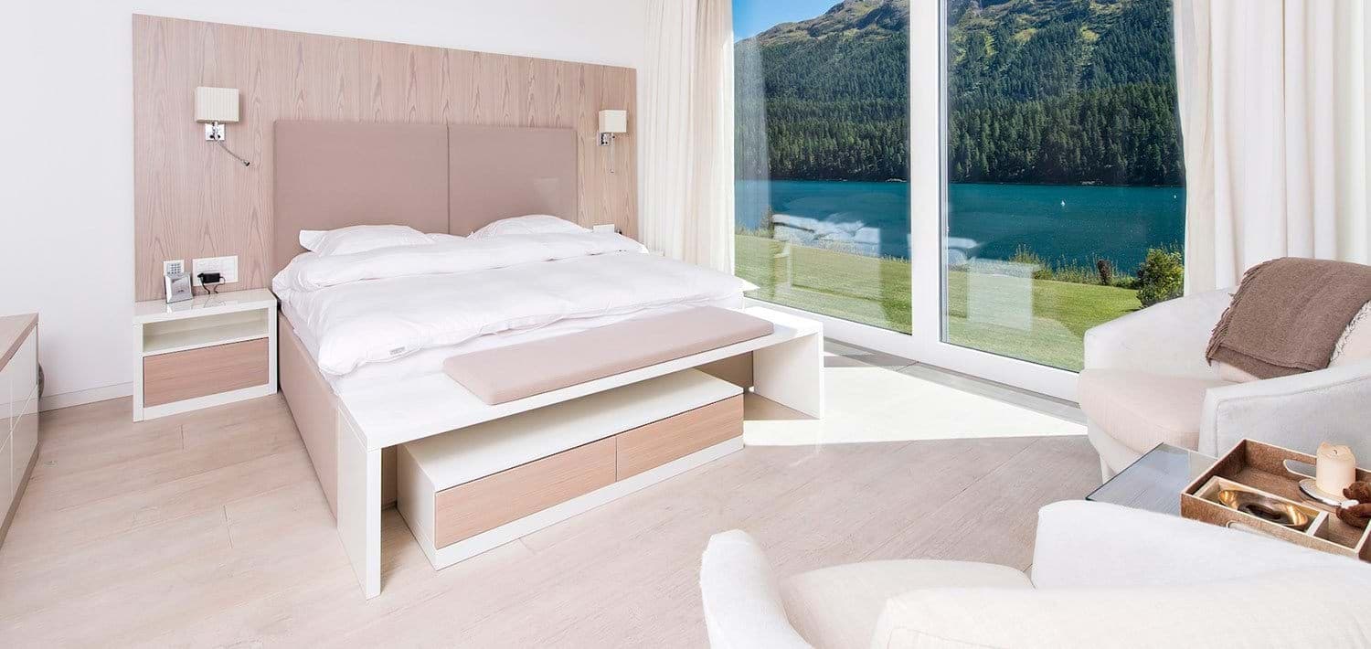 Primary bedroom with king bed and floor-to-ceiling lake views