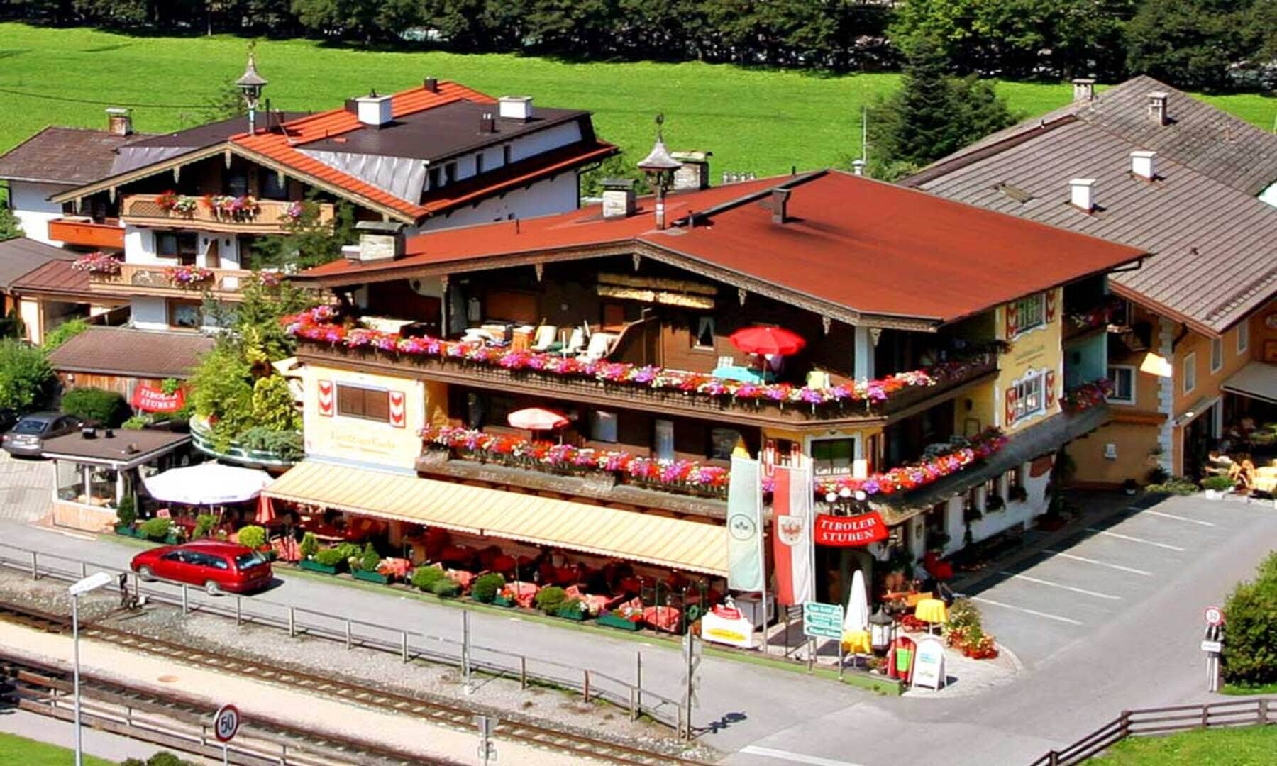 Chalet exterior featuring wrap-around balconies and ground-floor restaurant with patio seating