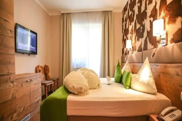 Guest bedroom with wall-mounted TV and cowhide print accent wall
